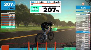 best smart turbo trainers link with compatible virtual training software. This image shows a picture taken from the on line Zwift game. It shows a rider in the centre of the screen and lots of data numbers around the edges