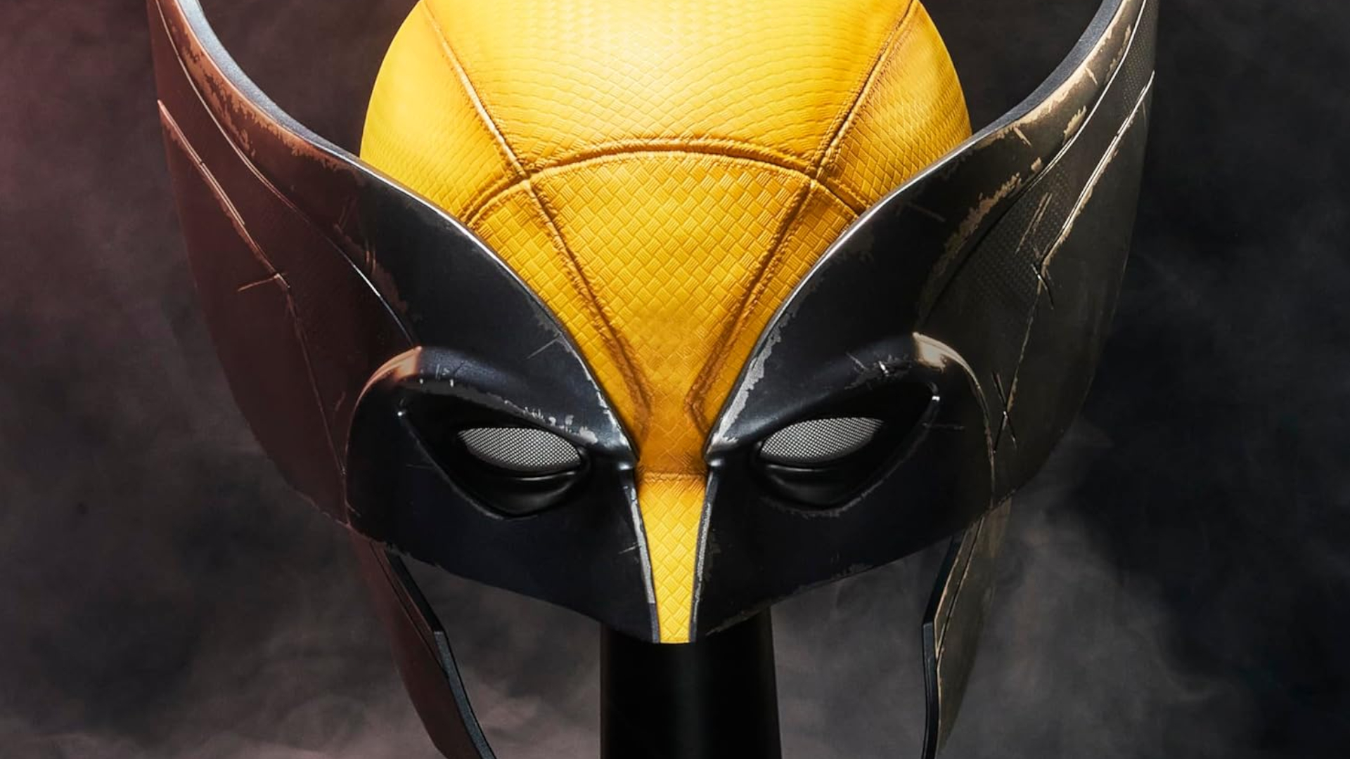 The Marvel Legends Wolverine Mask on a stand against a dark background, facing the viewer