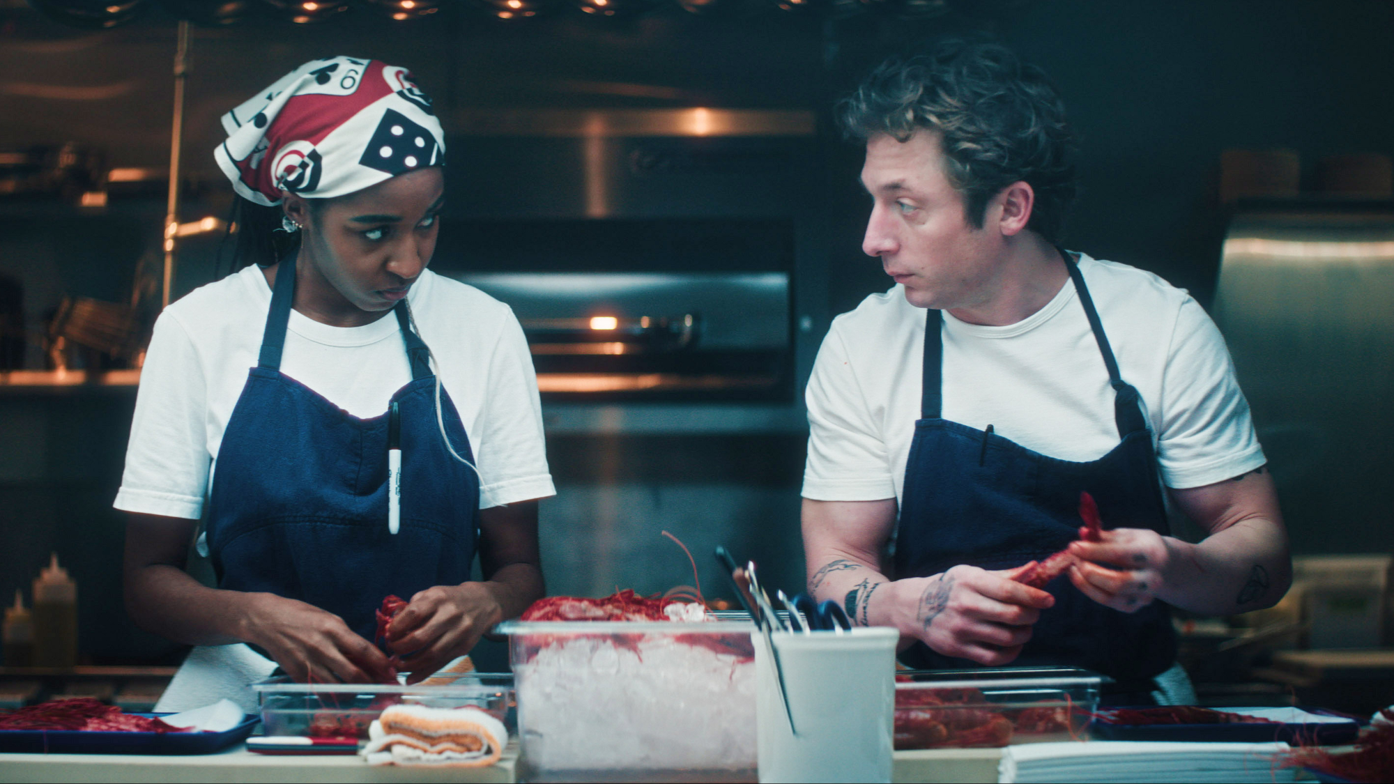 Sydney Adamu (Ayo Edebiri) and Carmy Berzatto (Jeremy Allen White) prepare food on The Bear.