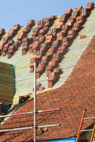 clay roof tiles being installed