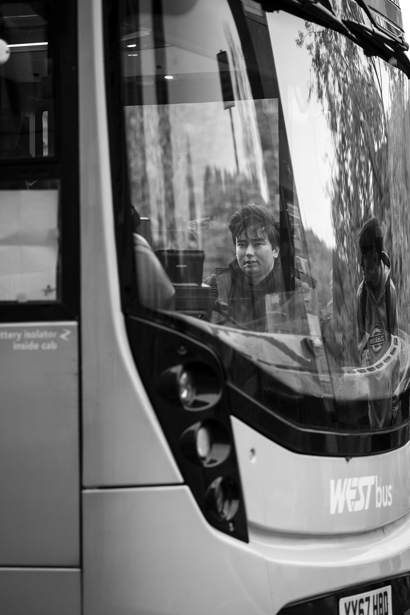 Black and white street photograph of man waiting for bus