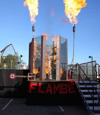 The Dunk Tank Flambé at the STEAM Carnival by Two Bit Circus. The tank spouts out flames instead of water when a player hits the target with a softball. Image is courtesy of photodepot.com and Two Bit Circus.