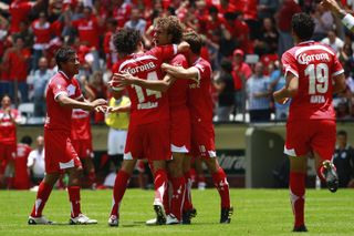 Toluca players celebrate a goal against Pachuca in August 2010.