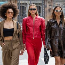 Julia Dalia wears brown blazer, pants, black top & Alessa Winter wears red leather jacket, transparent skirt, black YSL bag, sunglasses & Anna Winter wears brown oversized jacket, black bag - getty images 2166017927