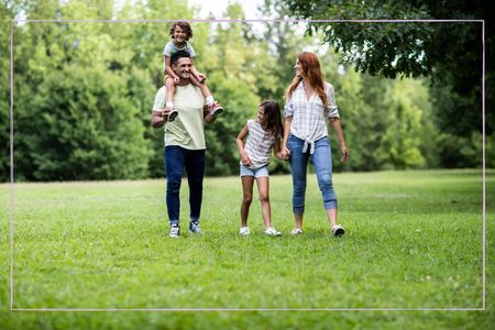 A family of four walking through a field