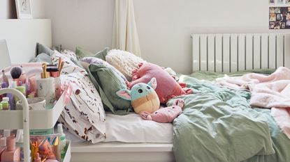 White room with bed cushions and plush toys, window