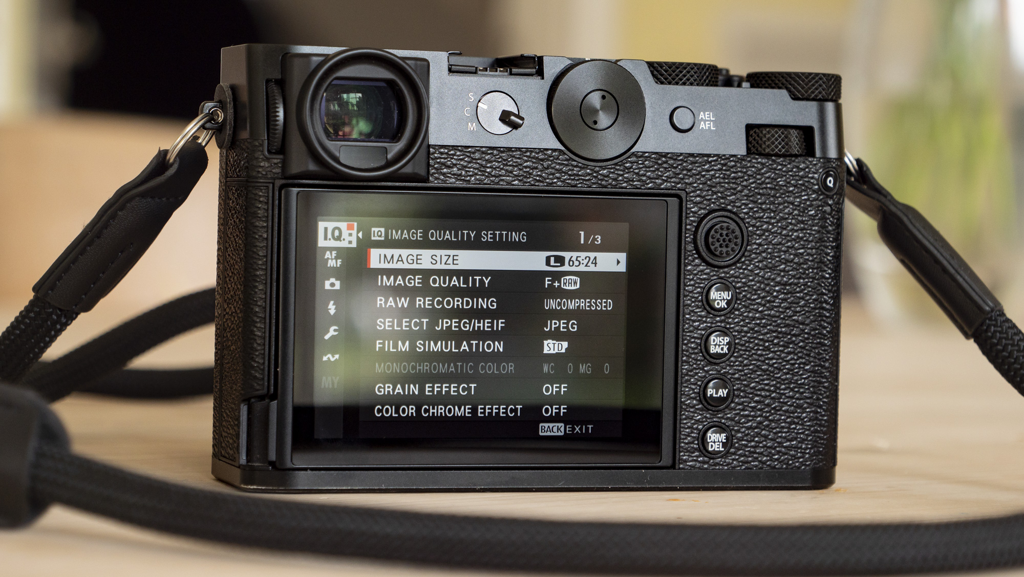 All-black Fujifilm GFX100RF rangefinder-style camera on a wooden table