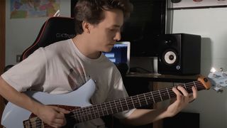 Matteo Mancuso playing guitar, with his laptop and speakers in the background