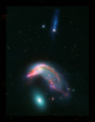 The galaxies NGC 2336 and NGC 2937 look like a penguin and its egg, respectively, in this photo, which incorporates data from NASA's Hubble and Spitzer space telescopes. 