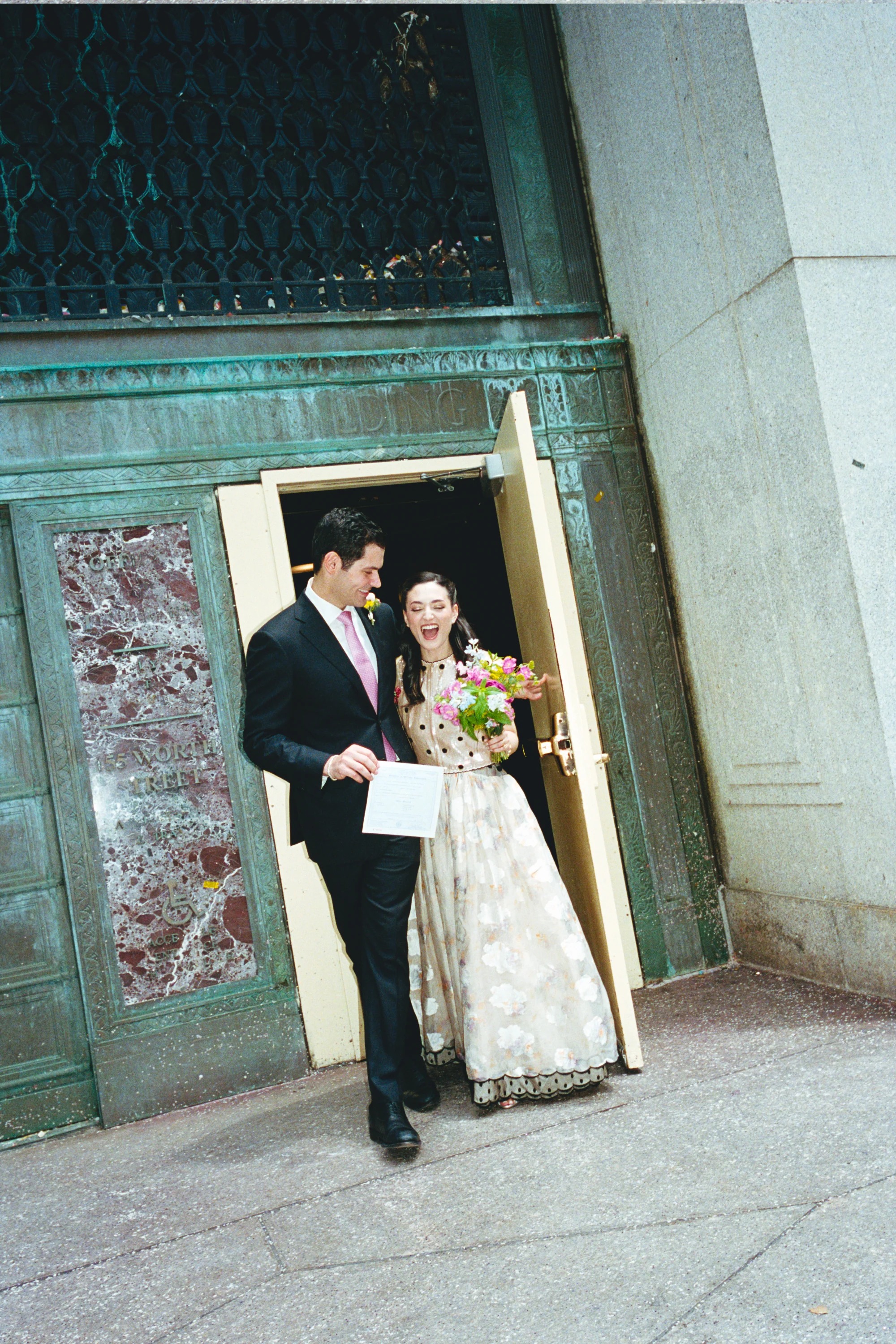 A bride gets married at a courthouse in a vintage wedding dress.