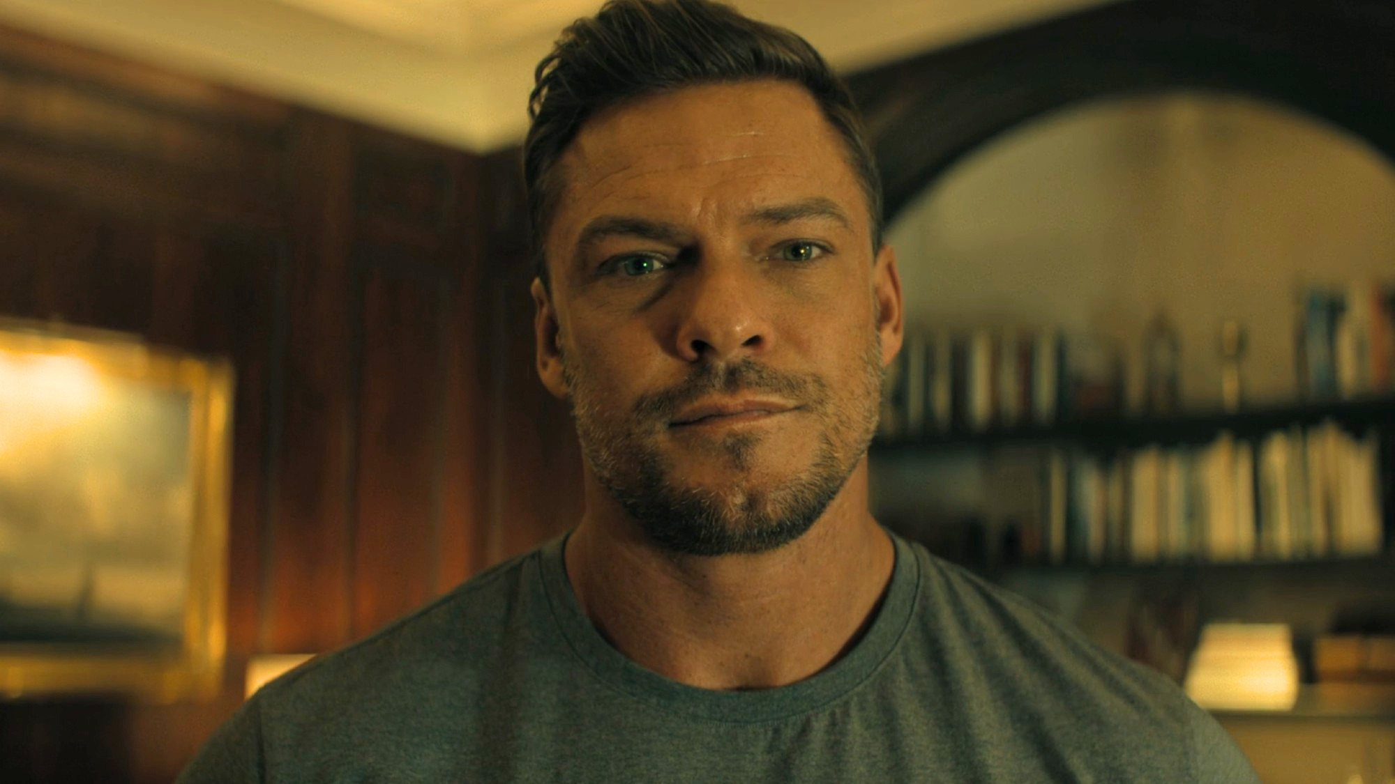 Alan Ritchson looking forward in Reacher. 