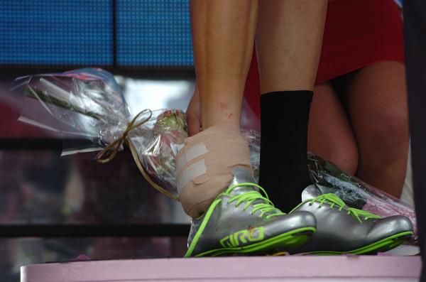 An ice pack is bandaged onto Taylor Phinney's ankle as he accepts his maglia rosa