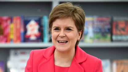 Nicola Sturgeon stands in front of books at a school in Prestwick, Scotland