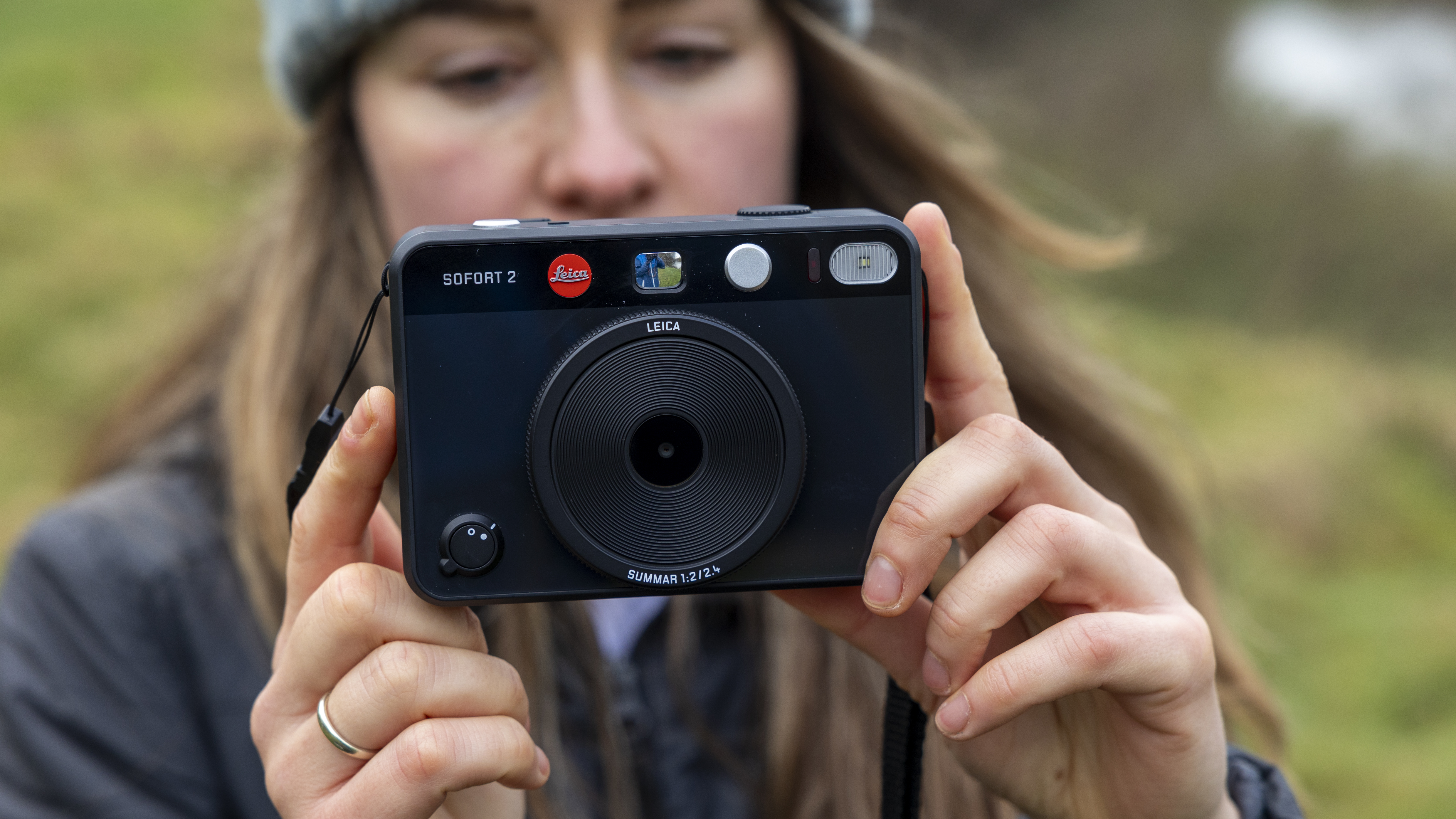 The Leica Sofort 2 being held by a woman in a field