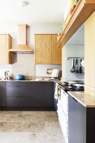 A kitchen with the doors of the drawers and units sprayed a dark grey to contrast with the oak wall cupboards