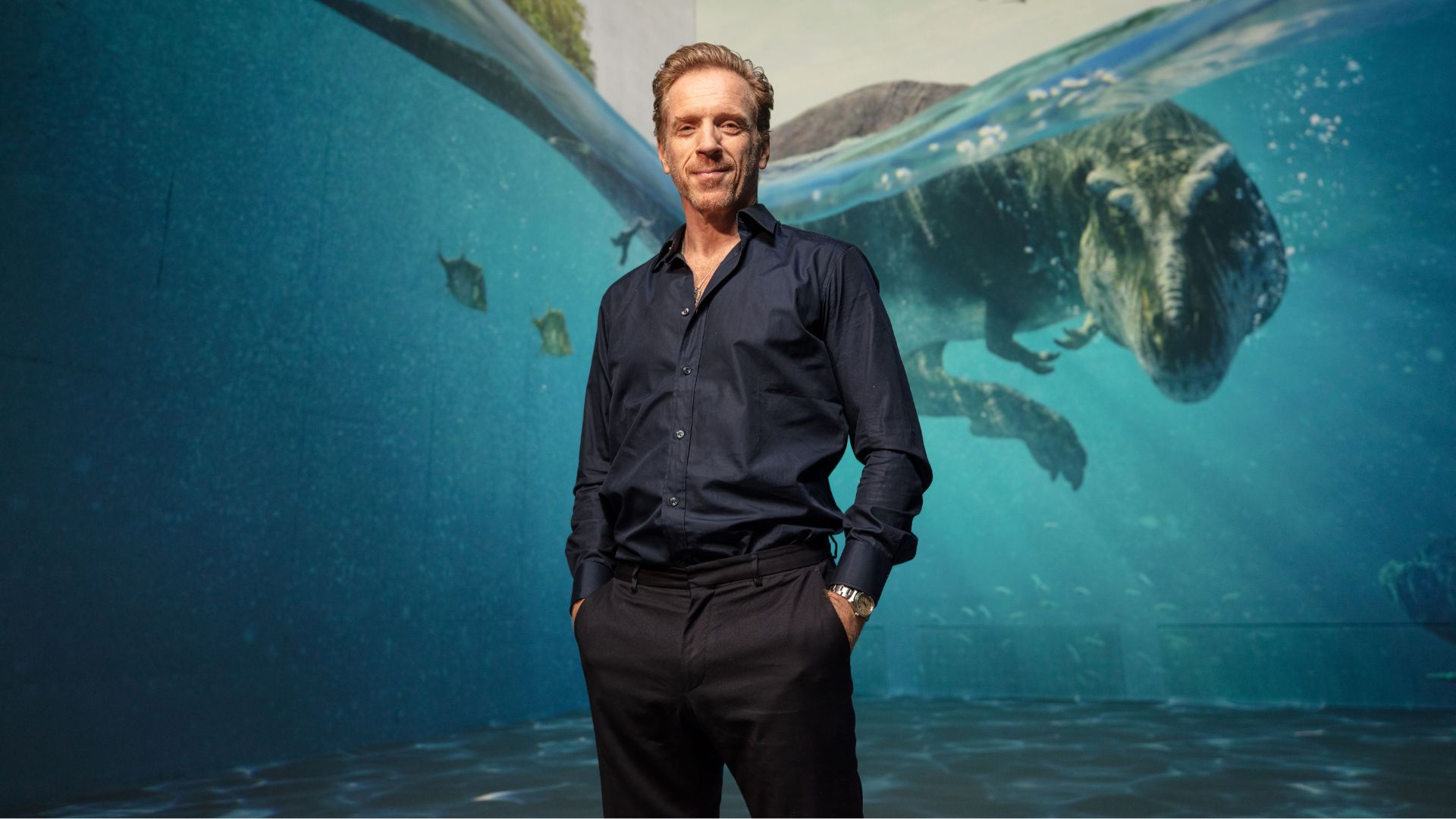 an image of damian lewis standing in front of one of the exhibit walls