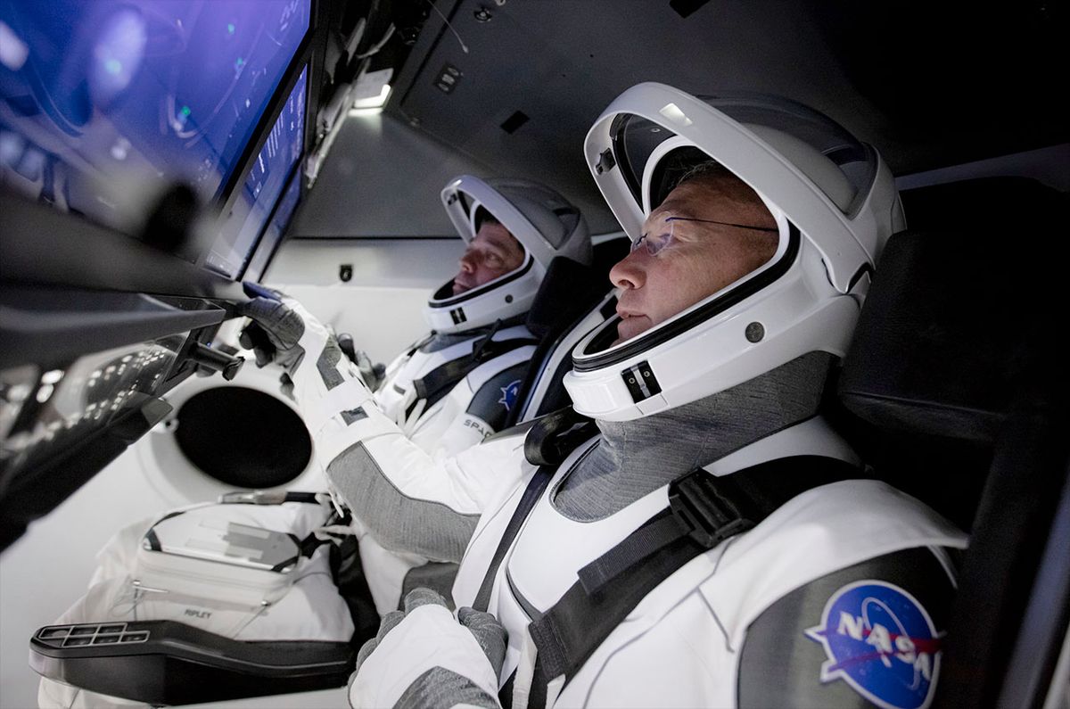 Demo-2 crewmates Bob Behnken (left) and Doug Hurley take part in a full simulation of launch and docking of SpaceX&#039;s Crew Dragon spacecraft inside a flight simulator. While learning how to fly the capsule, the two astronauts made suggestions to SpaceX but avoided customizing the Dragon to fit their preferences.