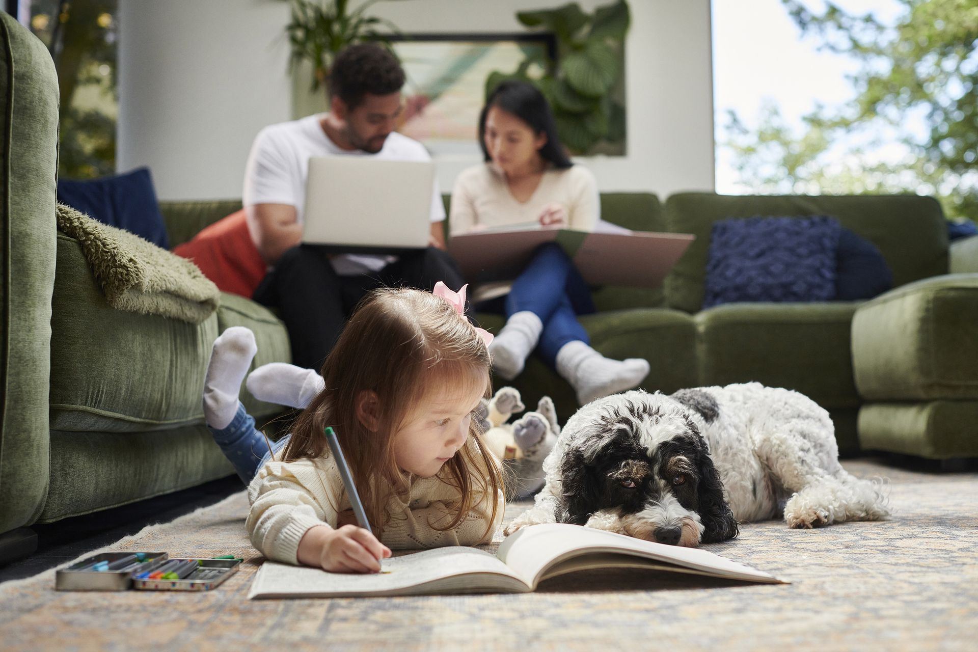 Little girl coloring with her pet dog