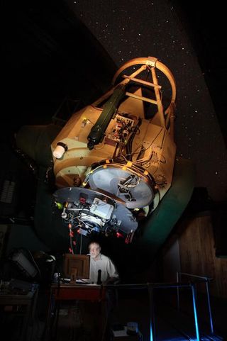 Astronomer Robert McMillan, discoverer of asteroid 2005 YU55, observing with an experimental instrument unrelated to his asteroid work in 2007, in the dome of the Steward Observatory's 2.3-meter Bok Telescope on Kitt Peak.