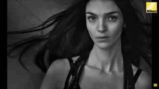 A still from of an image taken By Peter Lindbergh featuring a portrait of of someone on a grey background