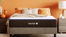 The Nectar Memory Foam Mattress on a bed against an orange wall.