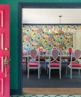 Colorful dining room with pink chairs and floral wallpaper