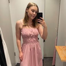 Woman in dressing room wears pink dress