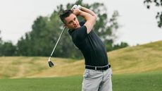 Man in a black shirt golfing