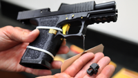 a 3D-printed "Glock switch" next to a seized gun