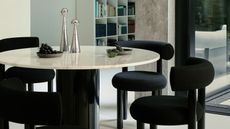black dining chairs around a white round table
