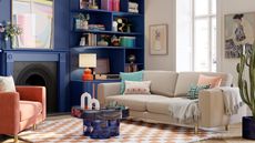 The best colors for south-facing rooms are useful to know. Here is a a living room with a dark navy blue bookcase with books and decor on it, a cream wall and a cream couch to the right with a dark blue table and white and brown checkered rug underneath it, and a pink armchair 