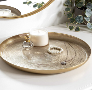round gold tray with trinkets on top