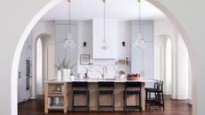 light kitchen with very tall ceiling and arched entryway