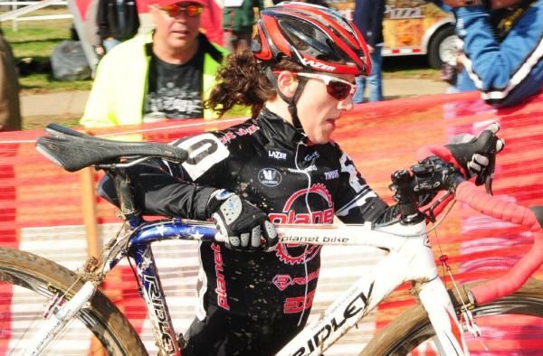 Kristen Wentworth (Planet Bike) hoisting her bike high over the barriers