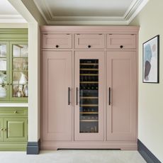 Tom Howley kitchen with green and pink cabinets and a built-in wine fridge