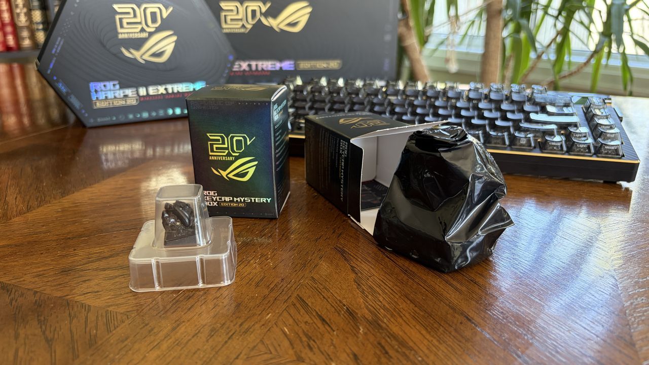 20th Anniversary ROG gaming products on a table with a keycap, boxes, and a keyboard.