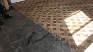 stained parquet floor being sanded