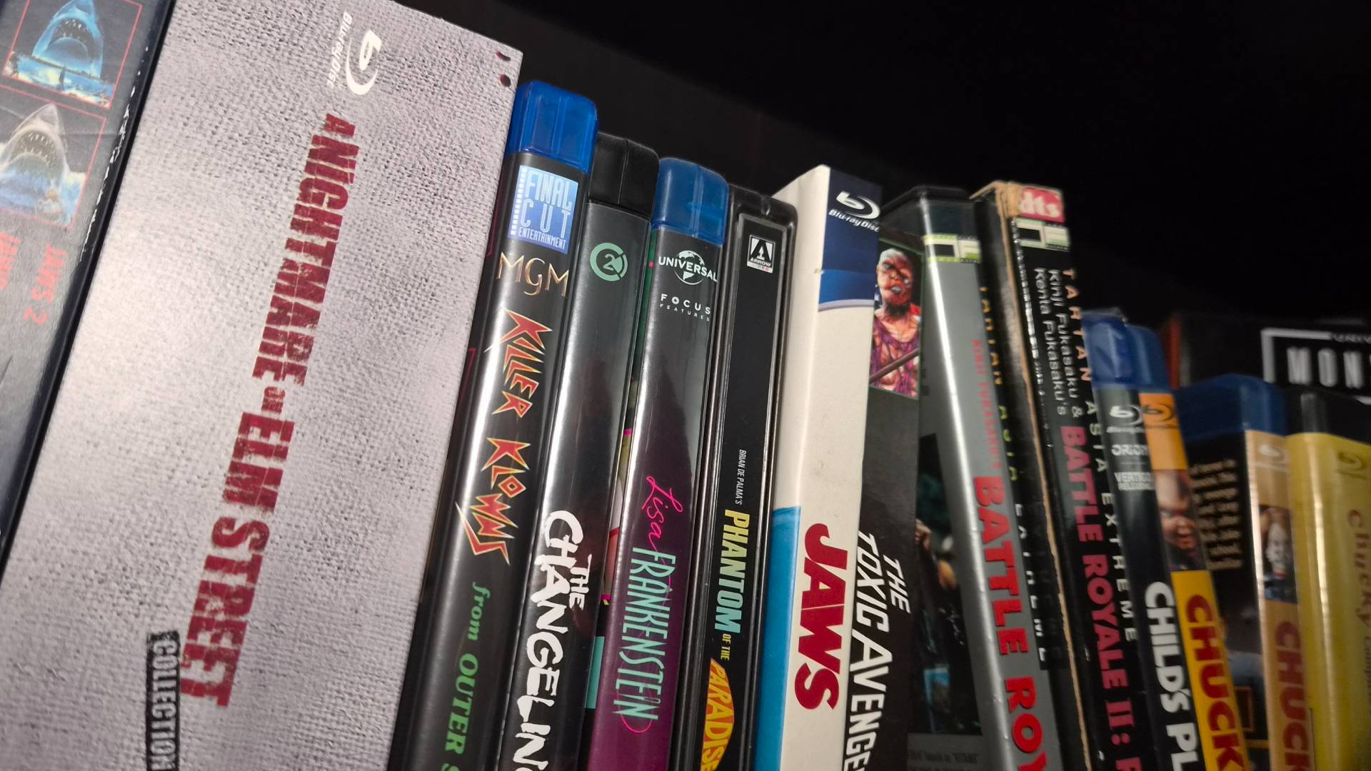 Photo of some horror Blu-ray and DVD releases sitting on a shelf.