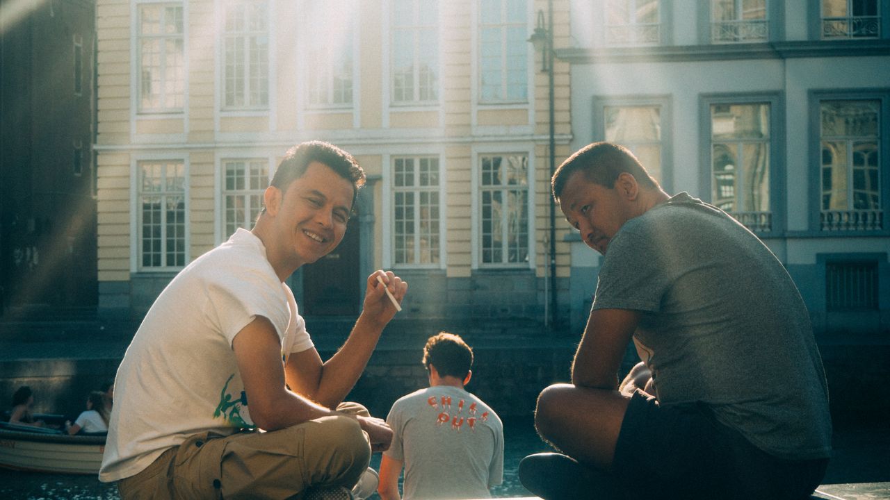 An image of two smiling men sitting on a bench, Olympus EM-5 Mark II sample images