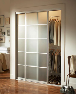 Brushed Nickel Aluminum Frame Mystique Glass Interior Sliding Door over closet in bedroom with polished hardwood floors