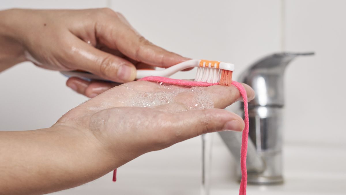 A person washing sport shoes laces under flowing water