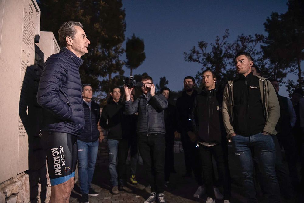 Team co-owner Ron Baron talks with the team after a day of riding