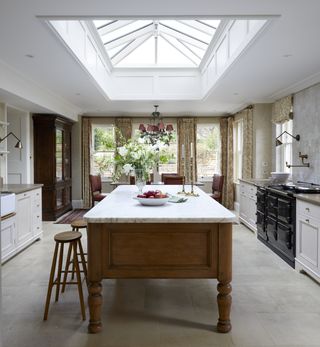 Large skylight above kitchen island with marble surface and traditional wooden base