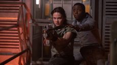 Rain and Andy prepare to use a prototype pulse rifle against an enemy in Alien: Romulus