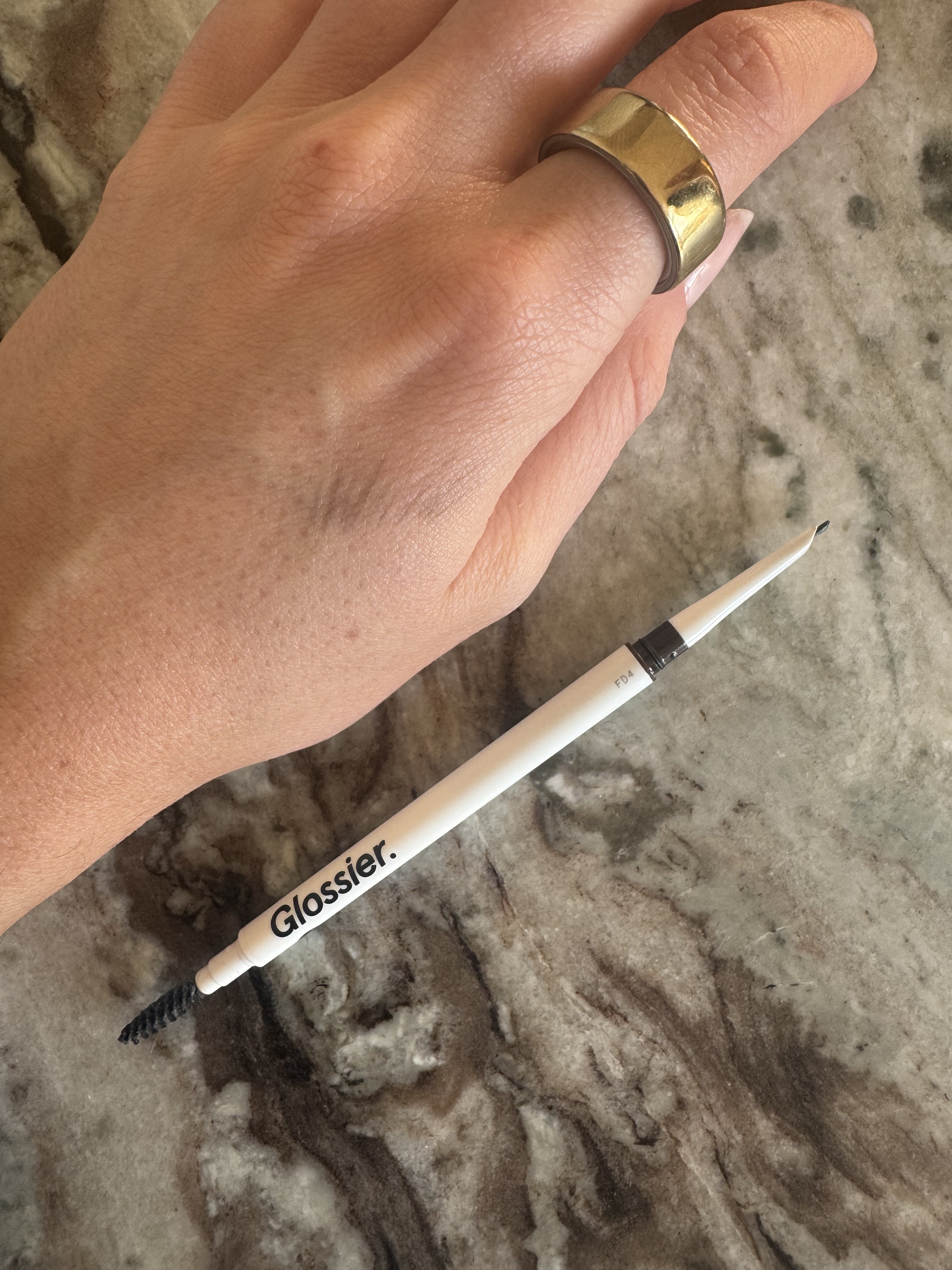 Beauty editor Eleanor swatching the Glossier brow pencil on her hand