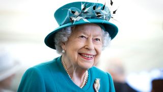 The Real Crown: A shot of Queen Elizabeth II in a teal hat and coat
