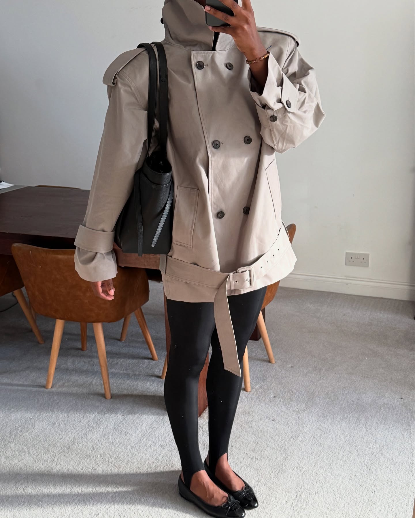 An image of @nlmarilyn wearing a funnel-neck cropped trench coat, one of the biggest winter trends to wear with leggings, stirrup leggings and ballet flats.