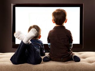Two young boys watching a TV.