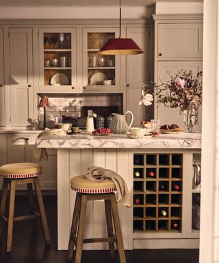 A warm and inviting kitchen with a vintage touch, featuring a bold red pendant light over a marble-topped island, creating both functional task lighting and a cosy, stylish atmosphere