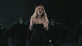 McKenna Grace singing as Ghostface killers surround her in music video for Ice Nine Kills Twisting the Knife